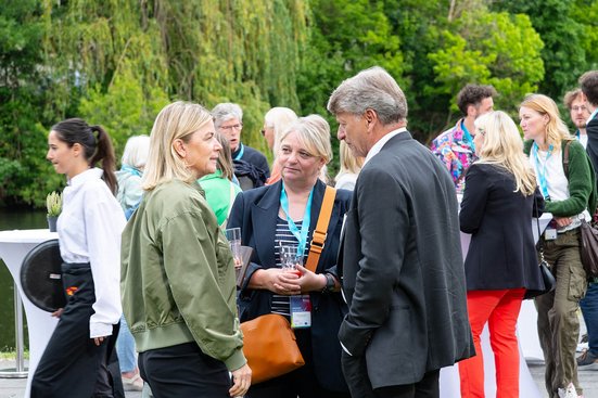 Gäste knüpfen Kontakte und tauschen sich bei einer Netzwerkveranstaltung des Businessplan-Wettbewerb Berlin-Brandenburg (BPW) in entspannter Atmosphäre am Wasser aus.