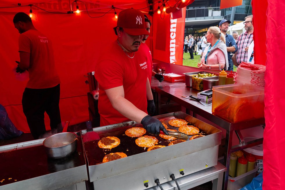 Burgerstand mit Grill, auf dem Burgerpatties liegen