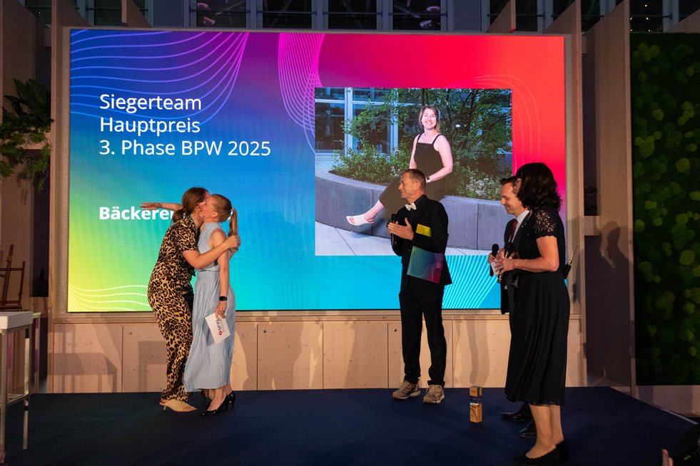Gründerin gewinnt einen Preis und umarmt die Moderatorin 