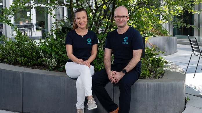Das Gründungsduo von Travee sitzt auf einer Bank