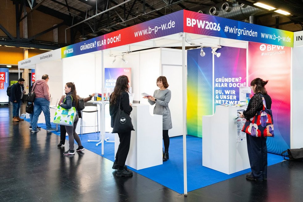 BPW-Messestand, eine Mitarbeiterin informiert einen Gast am Stand.