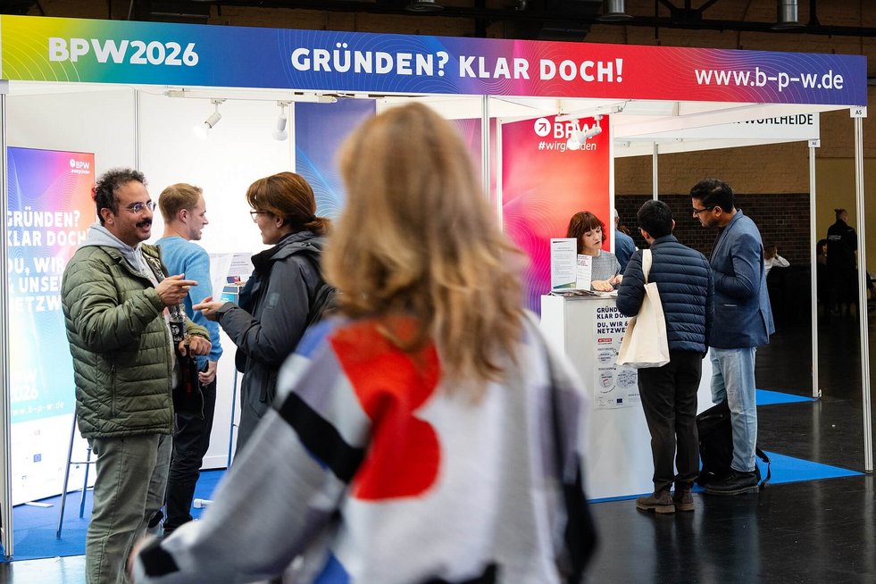 Mehrere Personen stehen vor dem BPW-Messestand und tauschen sich aus. 