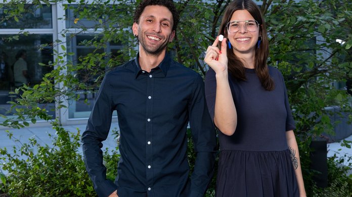 Das Gründungsduo von Blueprint Biomed steht für ein Foto zusammen. Die Gründerin hält das Produkt in der Hand und zeigt es in die Kamera.
