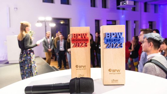 Pokale und ein Mikrofon stehen bzw. liegen auf einem Stehtisch