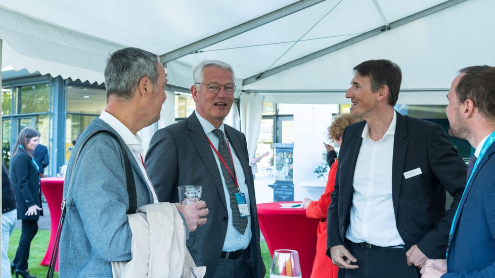Gastgeber und Moderator unterhalten sich mit weiteren Gästen