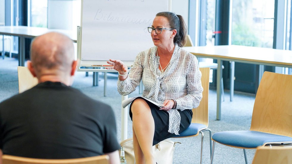 Referentin spricht mit Teilnehmer:innen