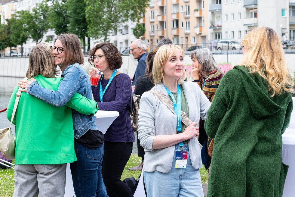 Gäste kommen bei einer BPW-Netzwerkveranstaltung miteinander ins Gespräch. Der Informationsstand der Nachfolgezentrale Berlin lädt zum Austausch über Unternehmensnachfolge ein.