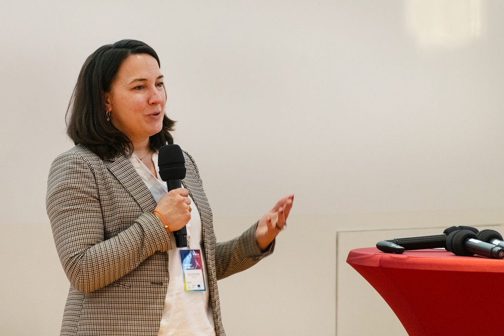 Referentin spricht mit Mikrofon bei einer Konferenz.