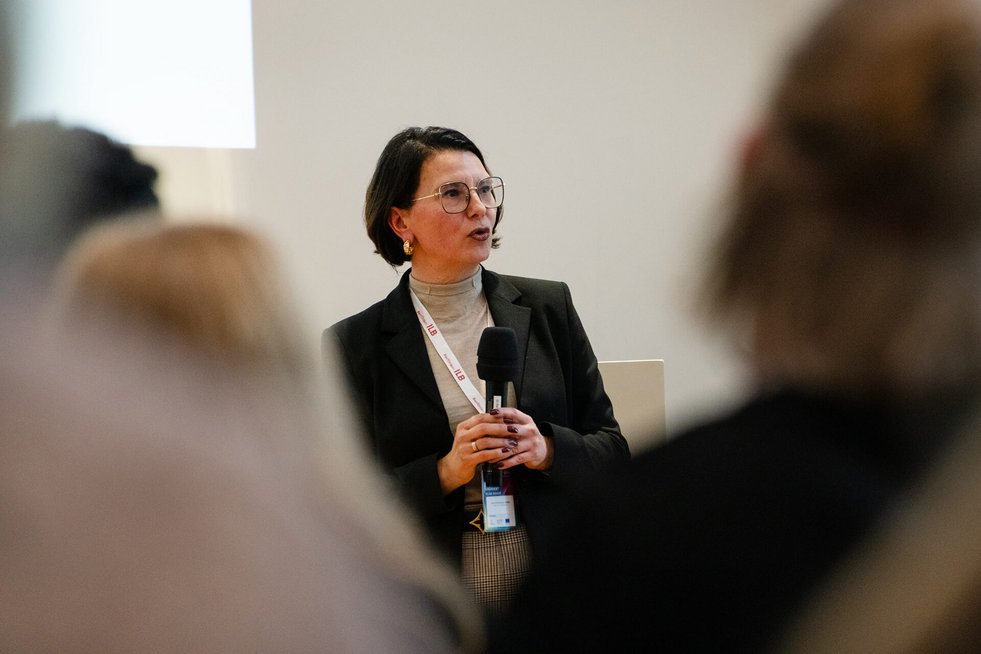 Referentin spricht mit Mikrofon vor Publikum.