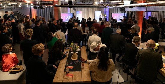 Blick in einen ausgebuchten Veranstaltungssaal mit vielen Gästen, die sich austauschen