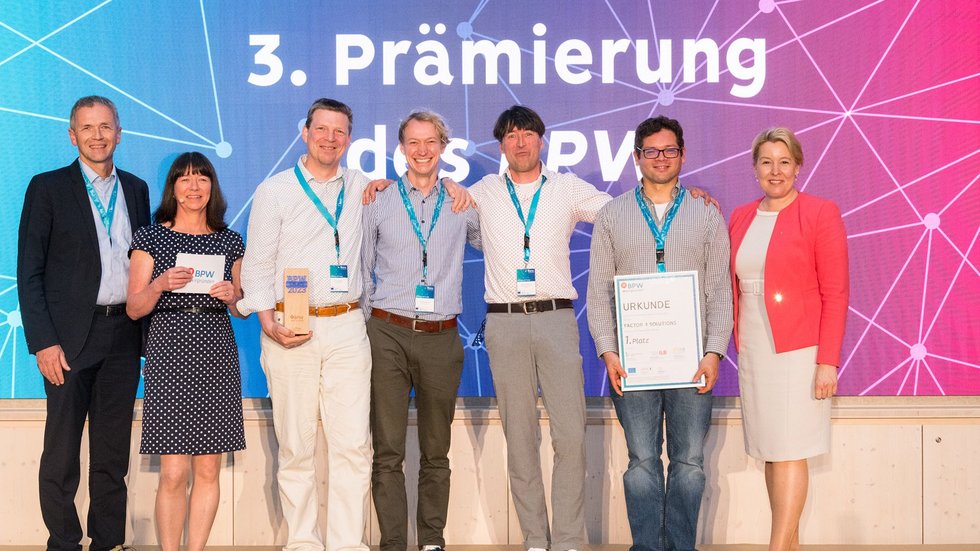 Auszeichnung des Siegerteams - sieben Personen stehen für ein Gruppenbild auf der Bühne