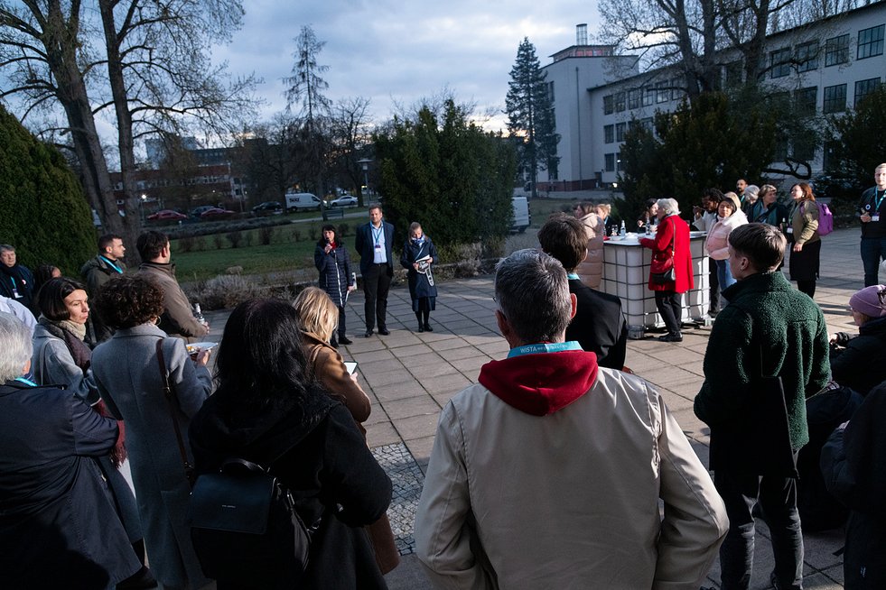 mehrere Personen stehen um ein Lagerfeuer 