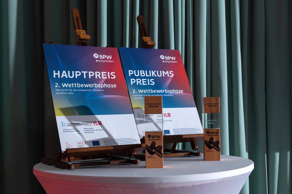 Zwei Auszeichnungen (Hauptpreis und Publikumspreis) des BPW-Wettbewerbs auf einem Tisch präsentiert.
