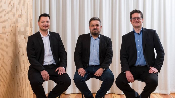 Drei Gründer sitzen auf Stühlen