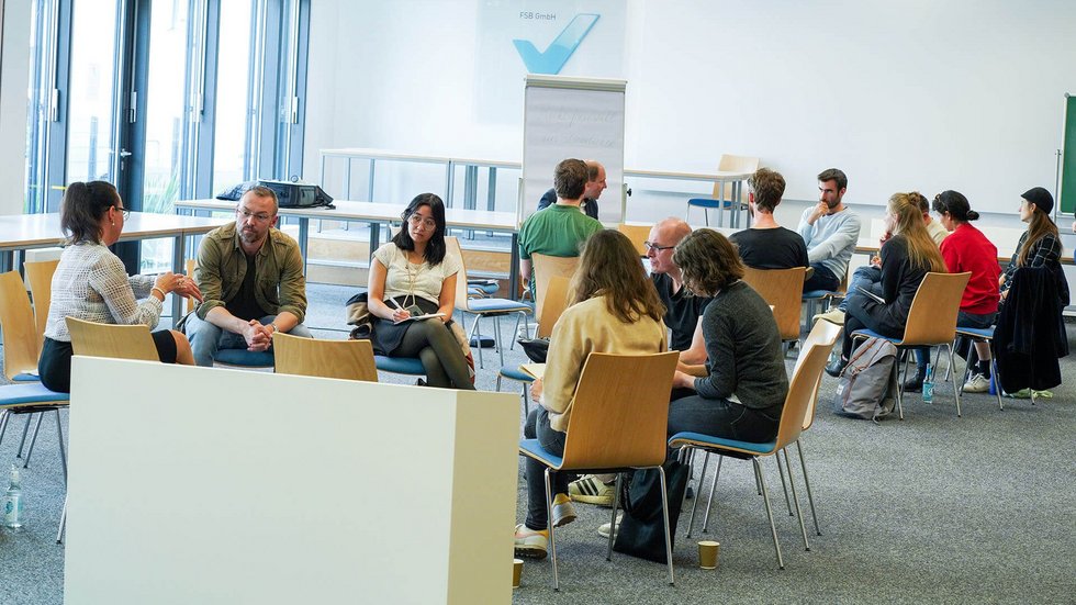 Workshopsituation in Kreisform mit Teilnehmer:innen