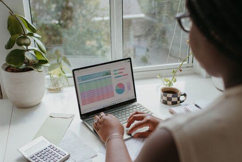 Frau sitzt an einem Laptop und arbeitet